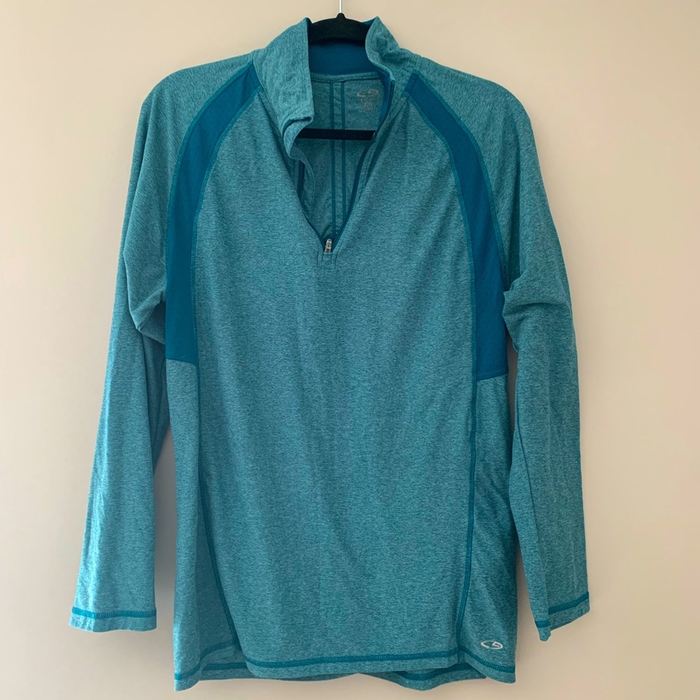 Teal long sleeve moisture wicking athletic top. Half zip, collared, reflective.